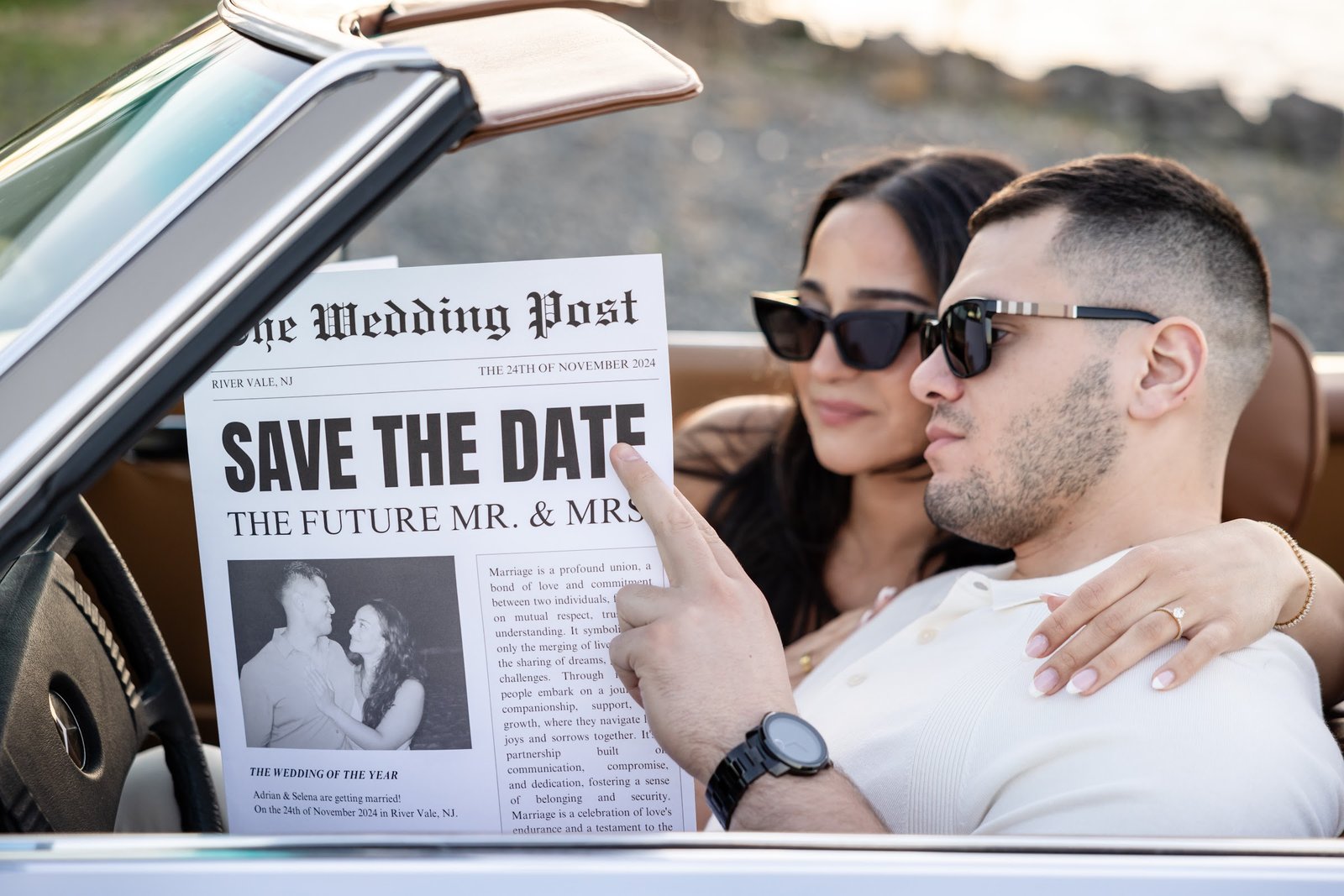Couple in sunglasses holding their save the date newspaper