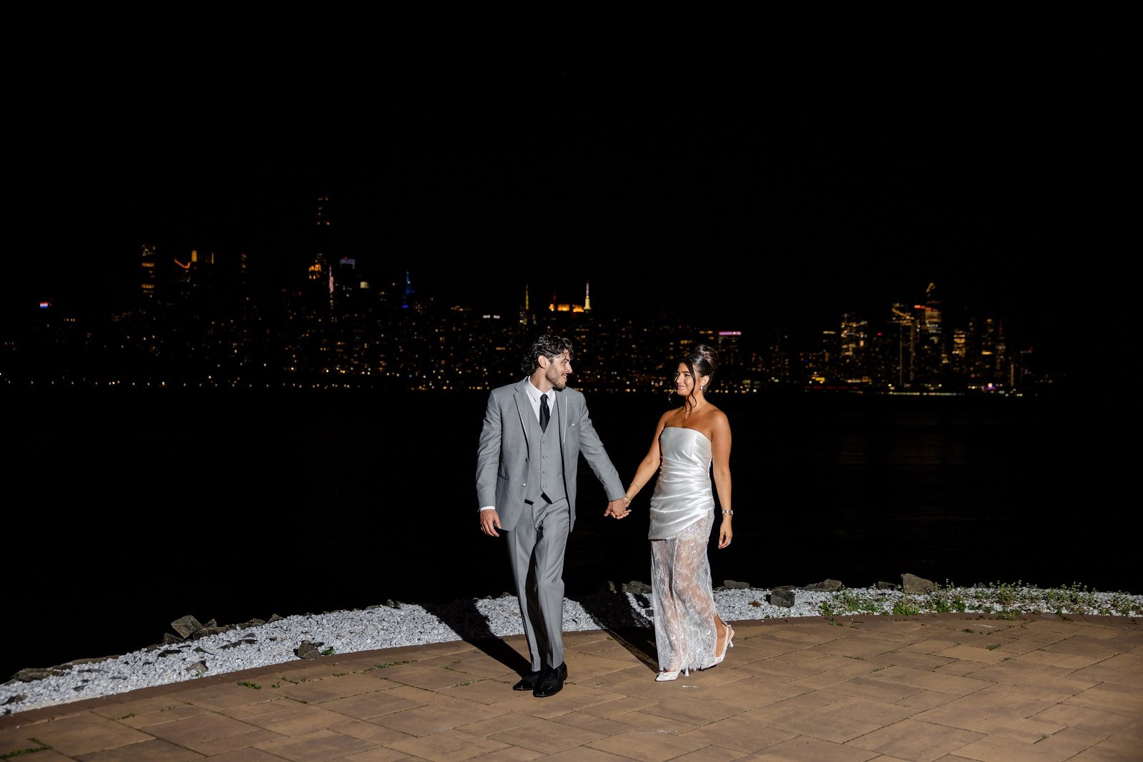 Couple celebrating at their engagement party by the waterfront at night