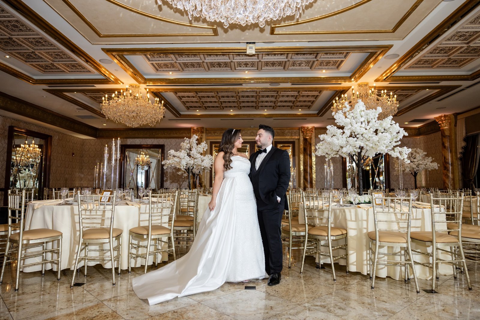 Couple in the reception hall surrounded by floral centrepieces