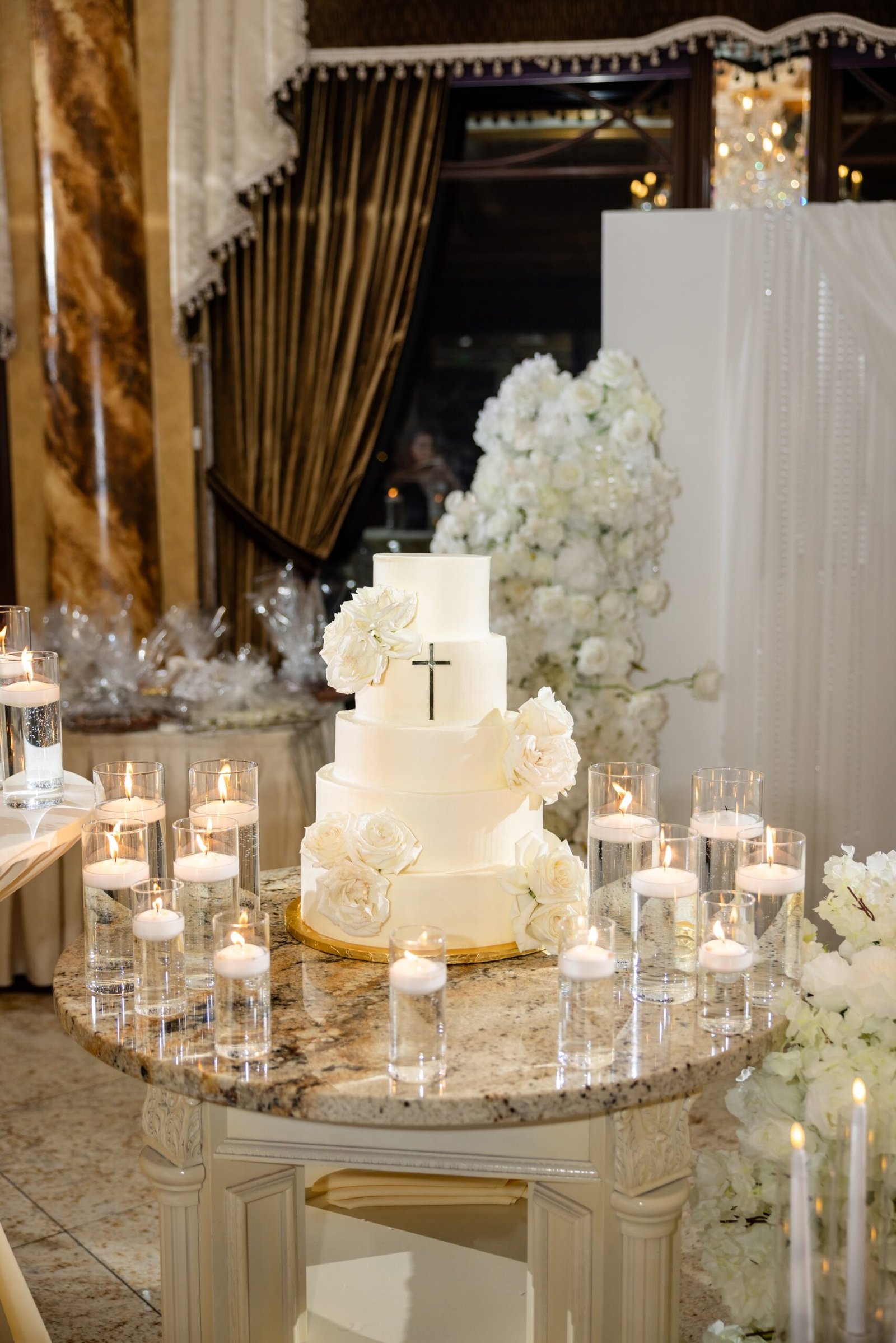 Tiered engagement party cake surrounded by candles