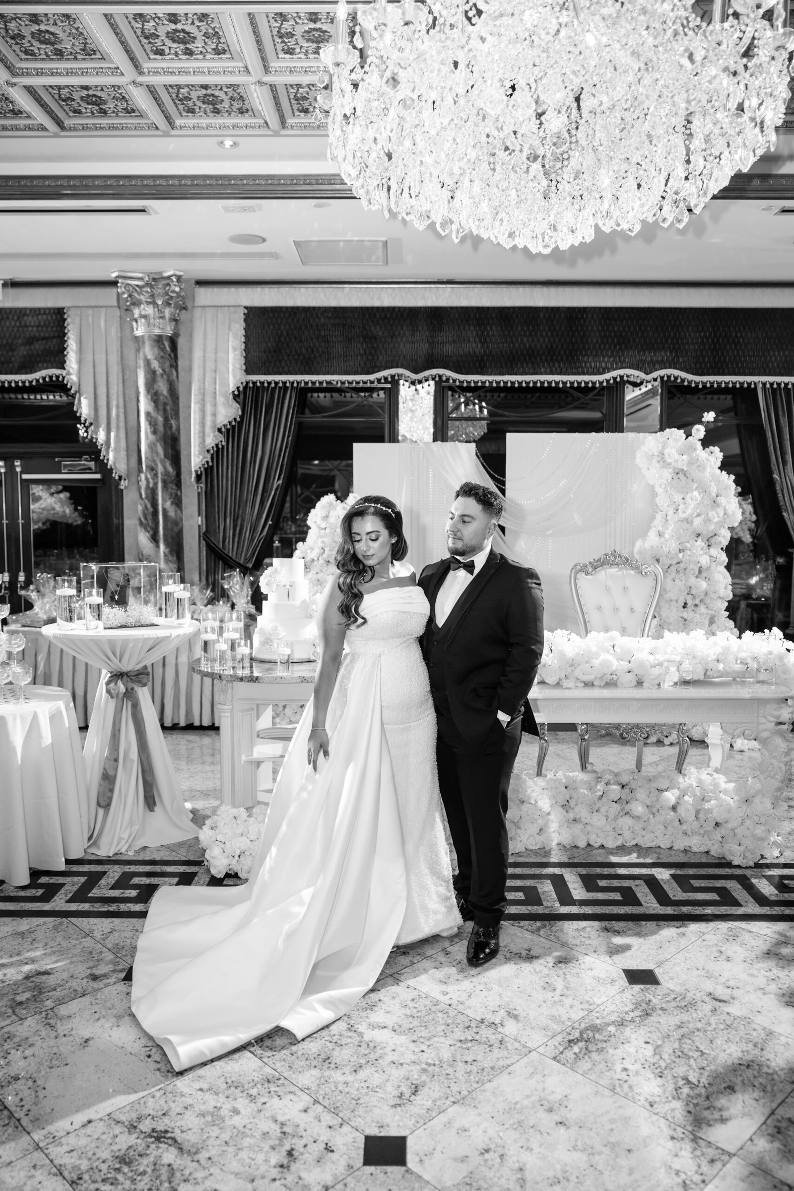 Black and white photograph of the couple beside the cake display