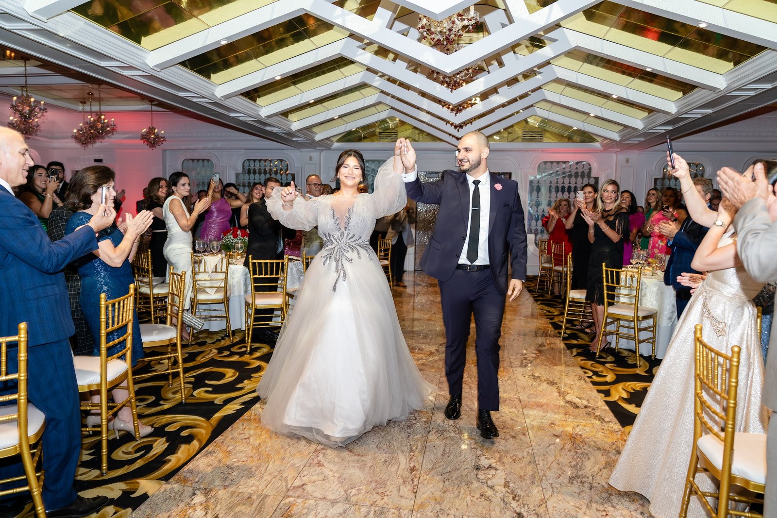 Couple making their entrance as guests cheer