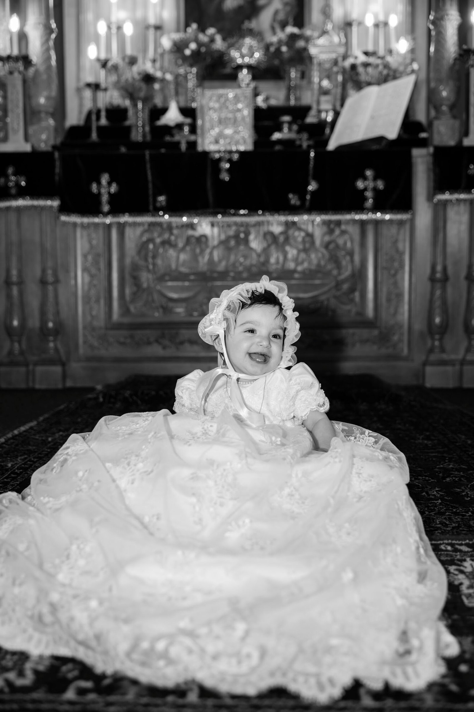 Baby in a christening gown at the altar, photographed by Team Zoom Studio