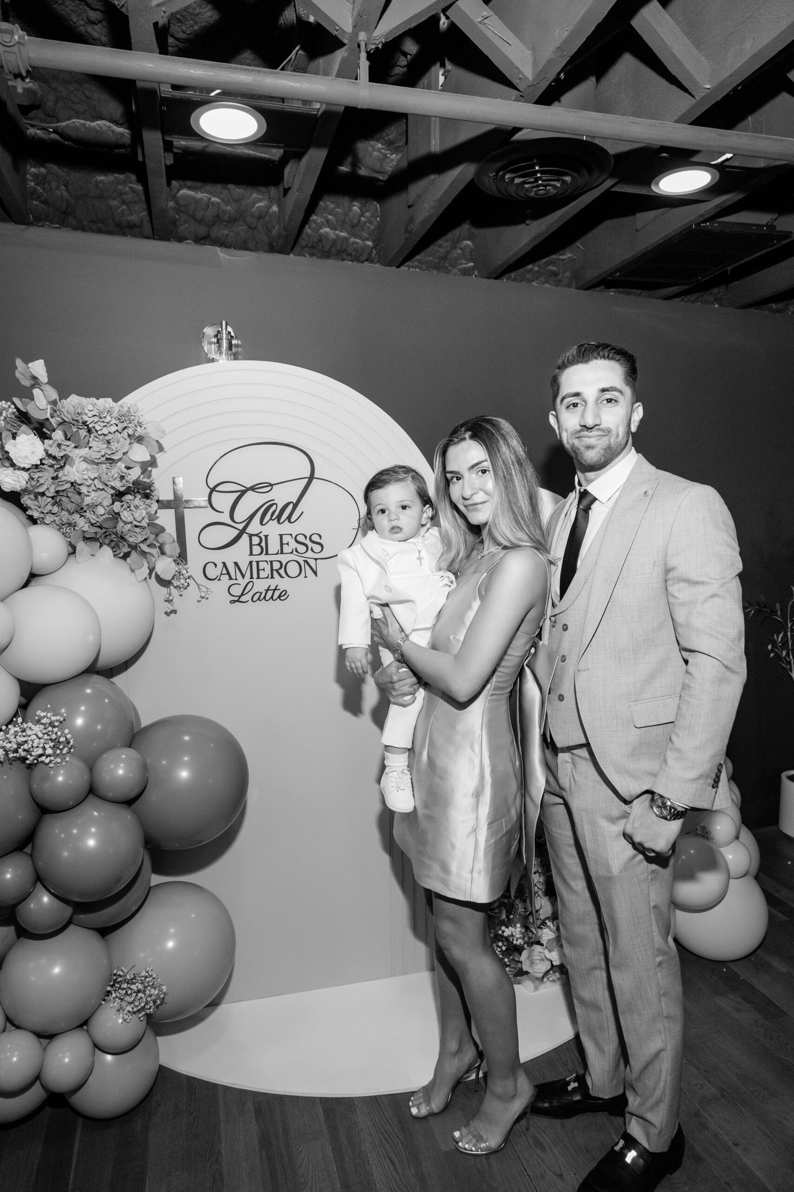 Black and white family photograph at the christening backdrop