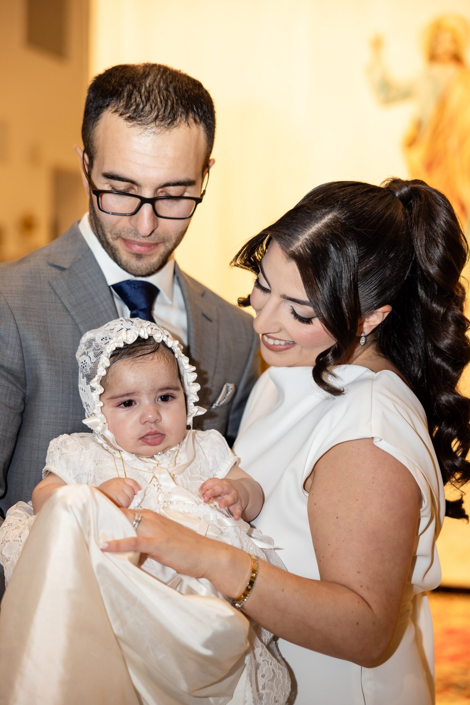 Mother holding her baby daughter on the christening day