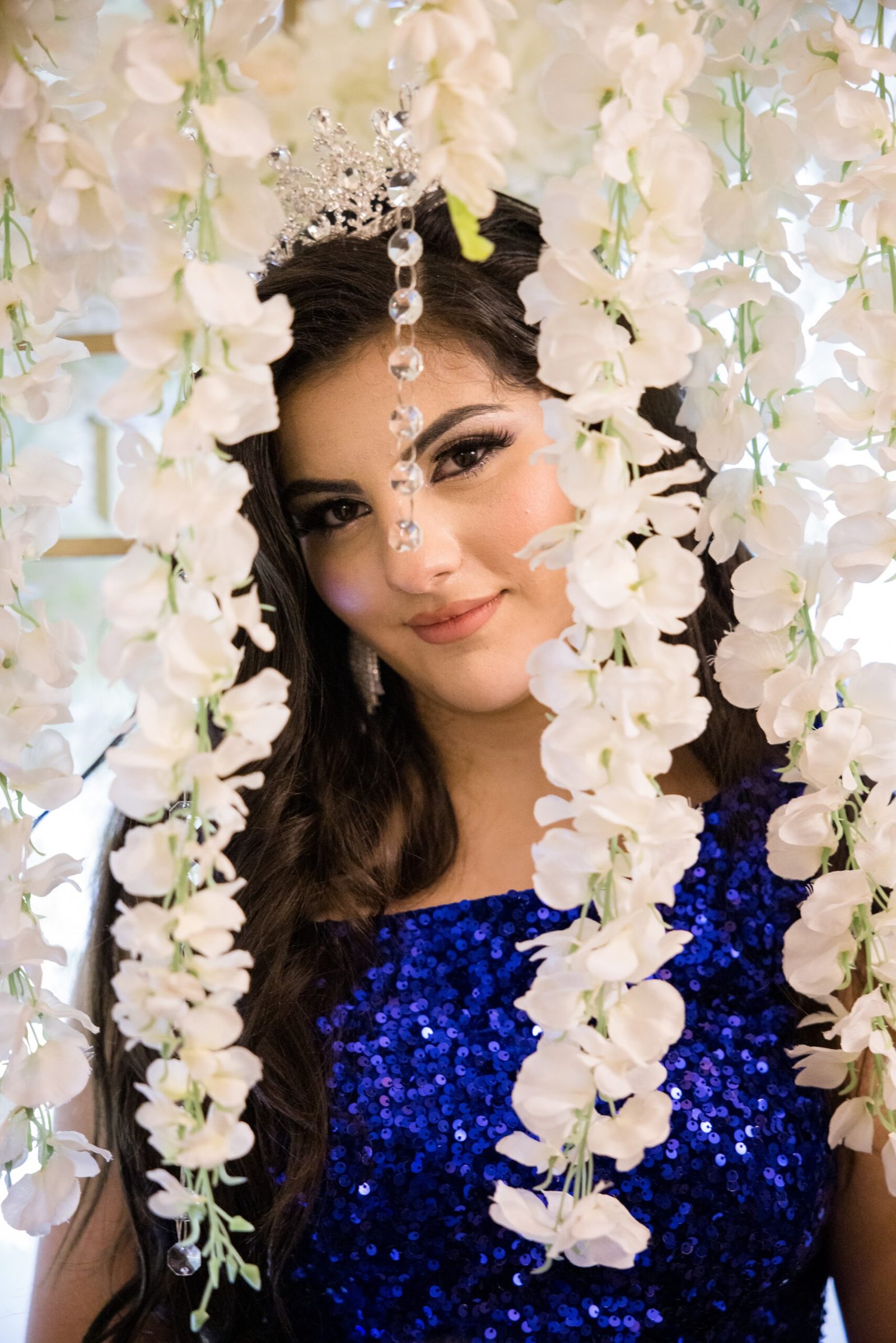 Sweet 16 portrait beside a floral wall