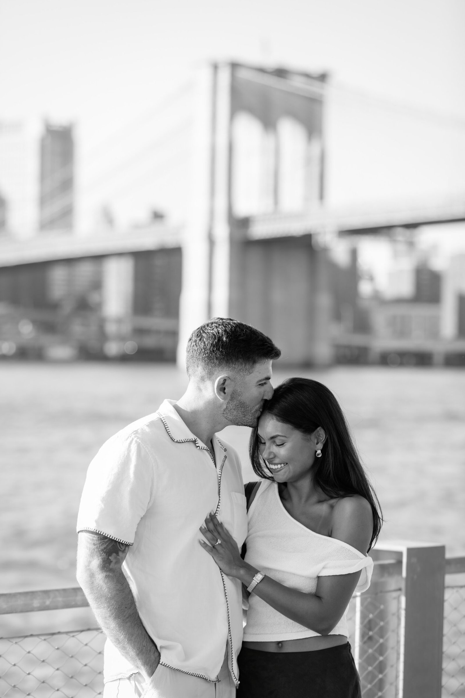 Black and white photograph of the couple embracing by the water