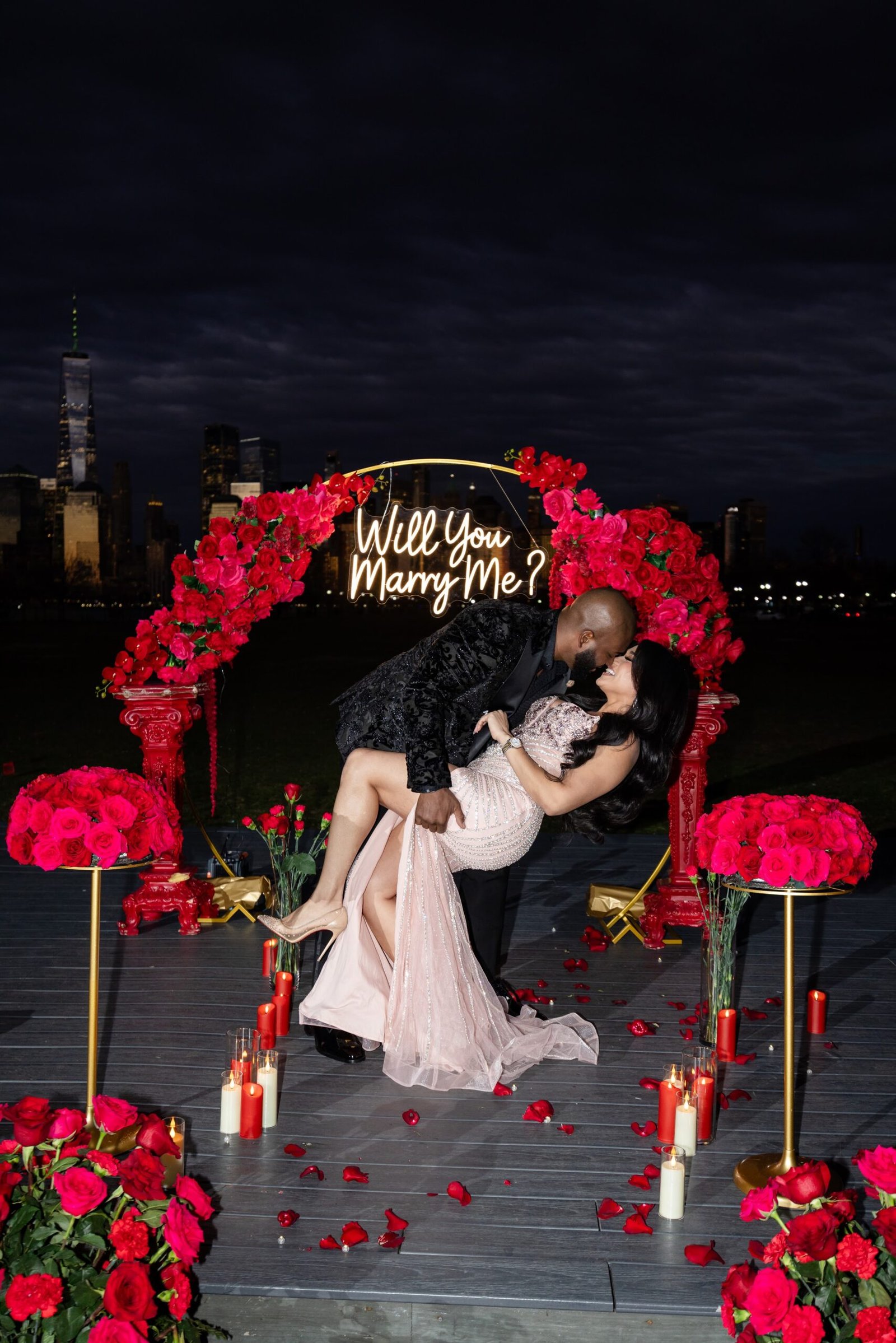 Celebratory dip and kiss beneath the rose arch