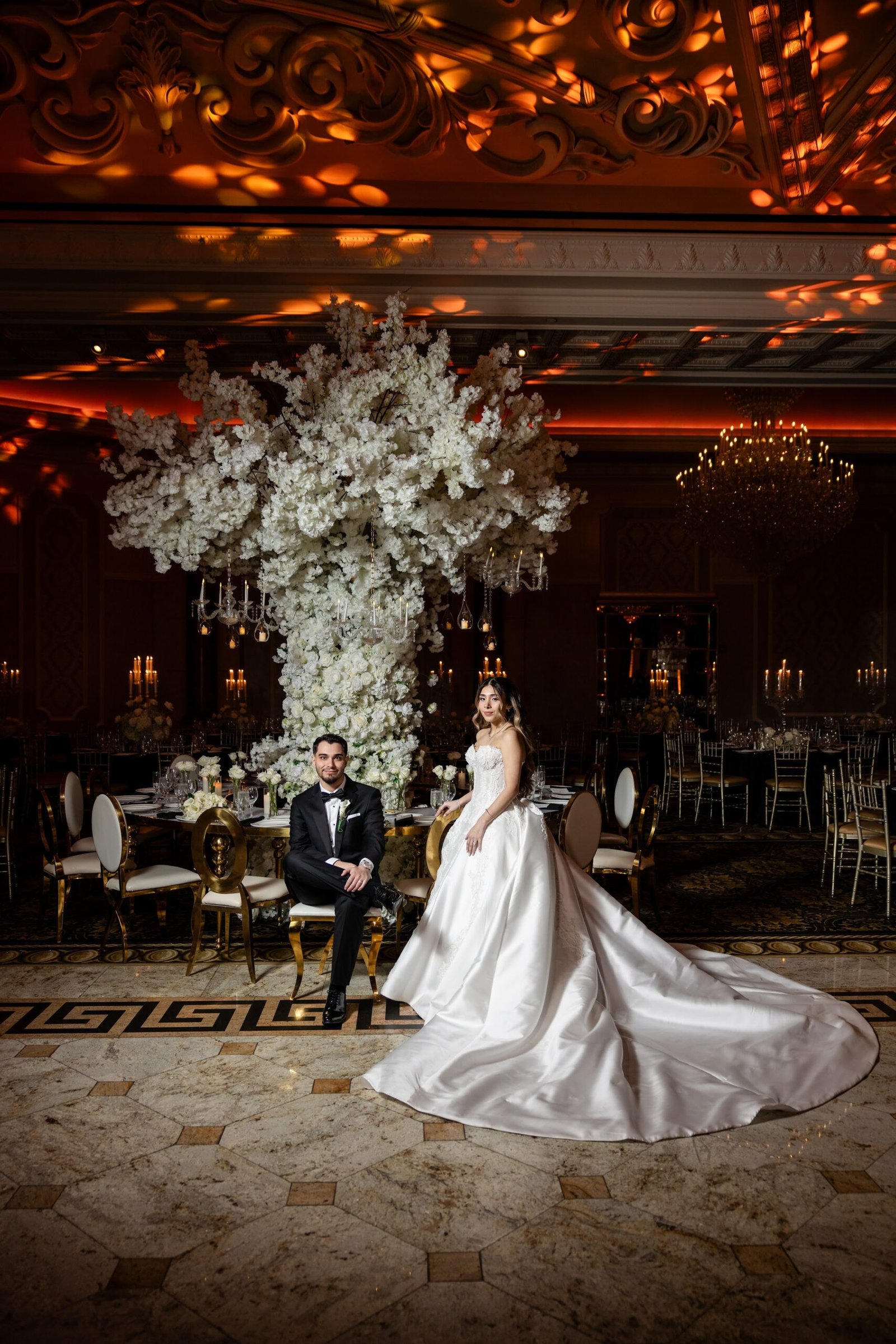 Wedding ballroom set with white florals and chandeliers, photographed by Team Zoom Studios