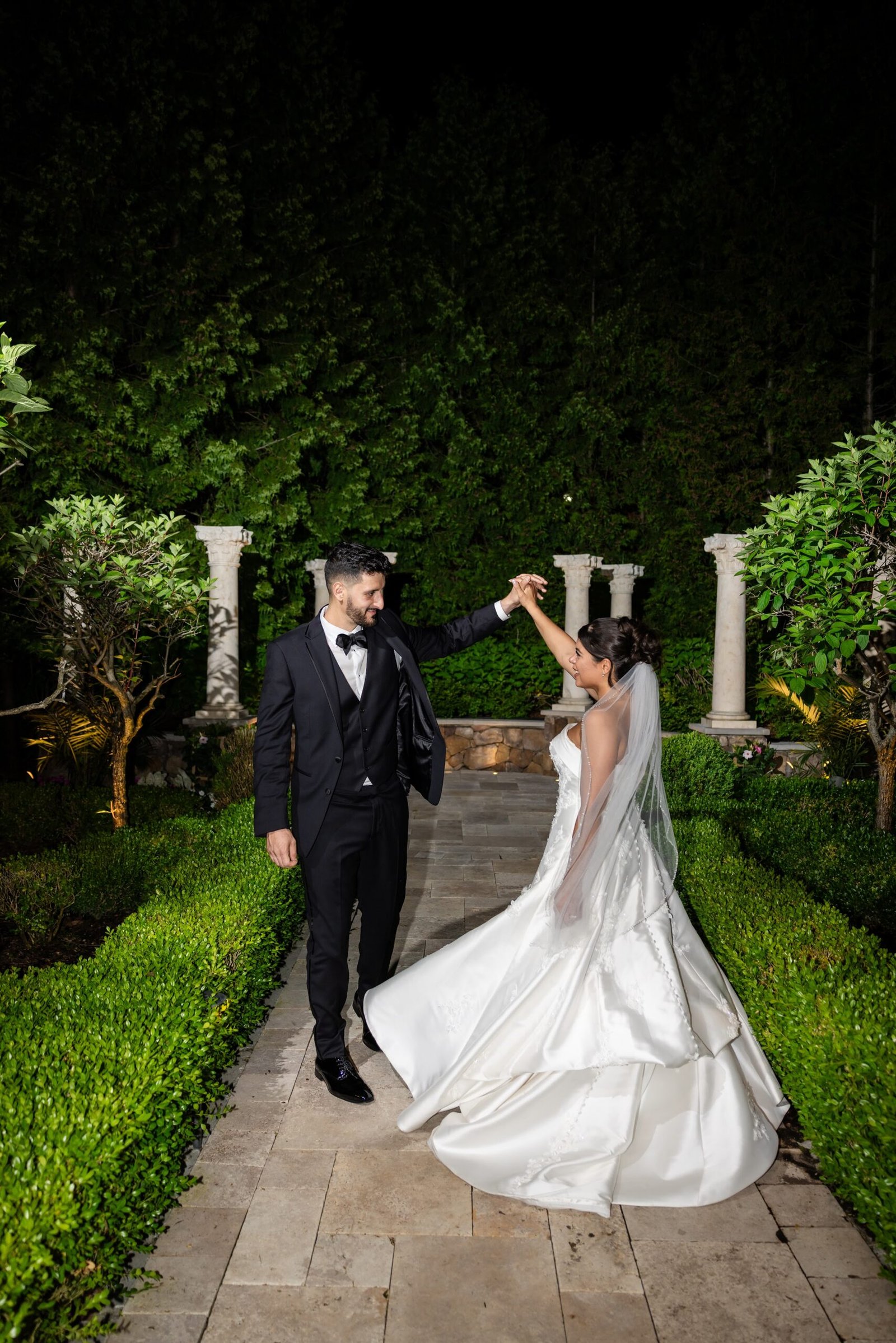 Bride and groom dancing in the garden at night