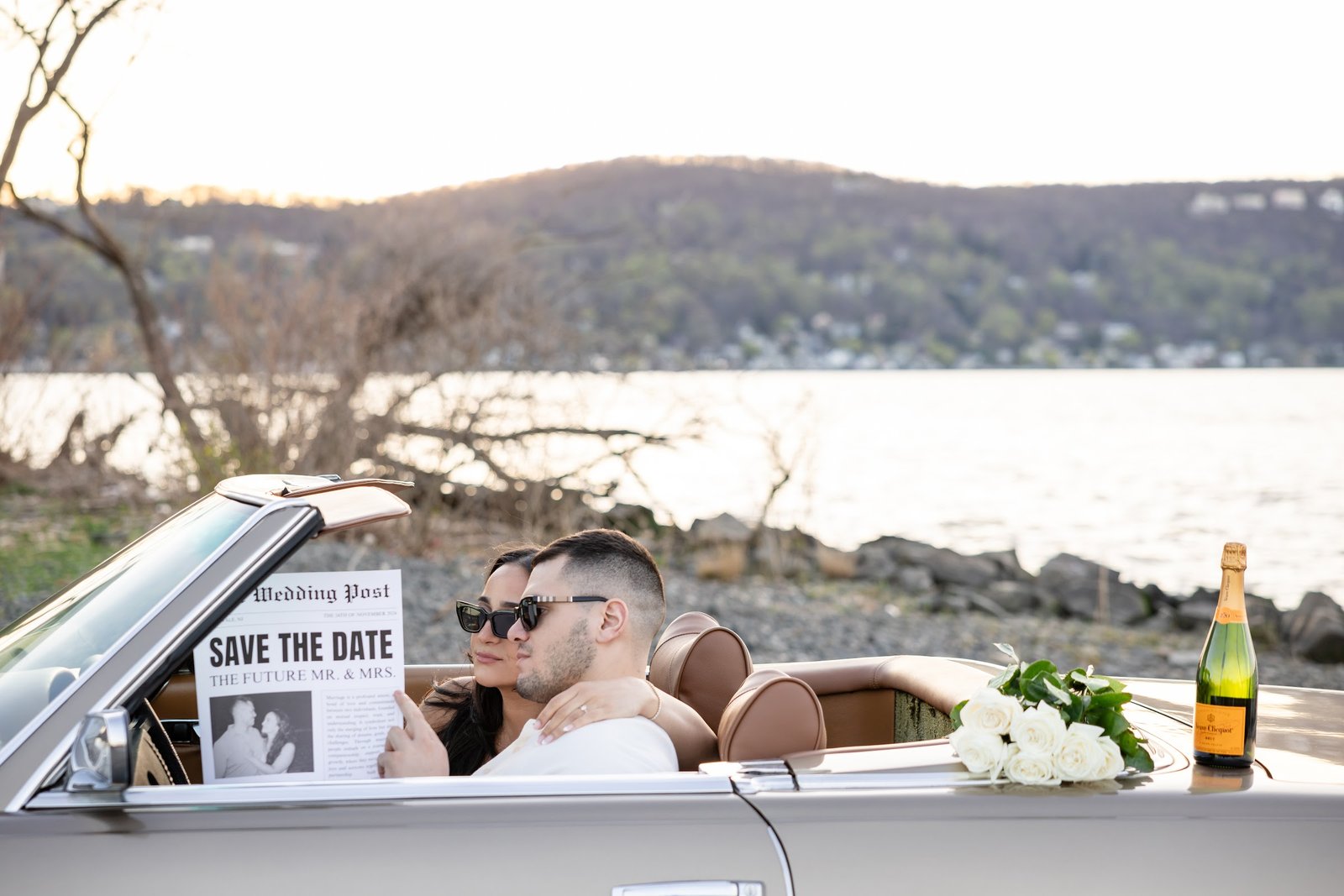 Engaged couple in a vintage car with a Save The Date sign